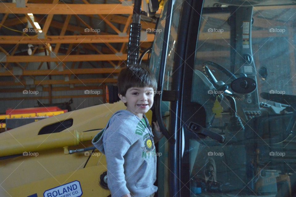 Little boy anxious to drive the tractor!