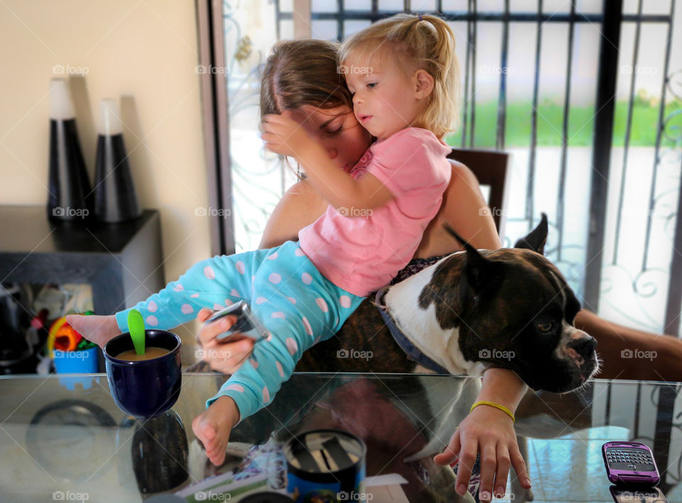 Woman and daughter having breakfast with the dog 
