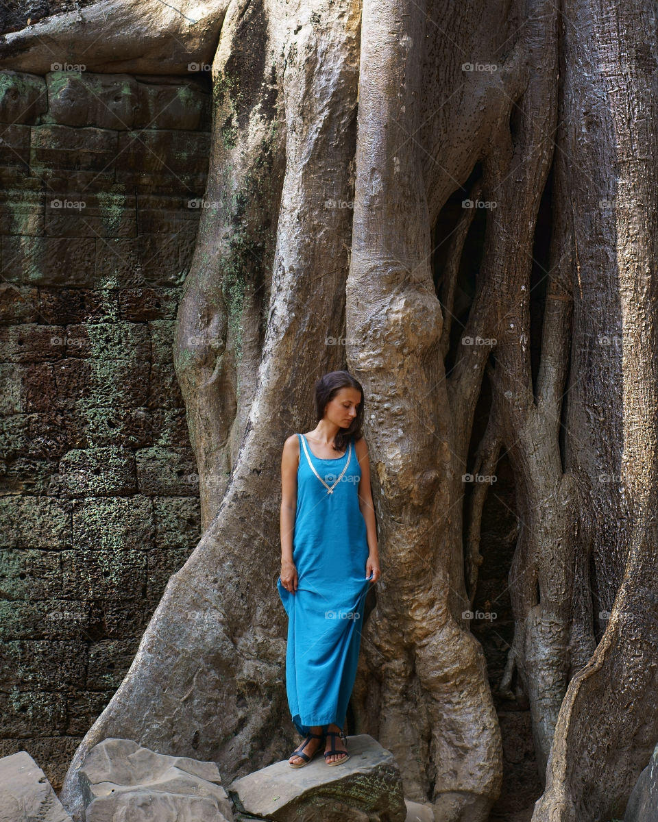 girl standing against tree in a beautiful dress