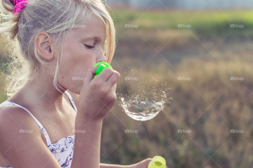 Soap bubble is bursting, girl is playing
