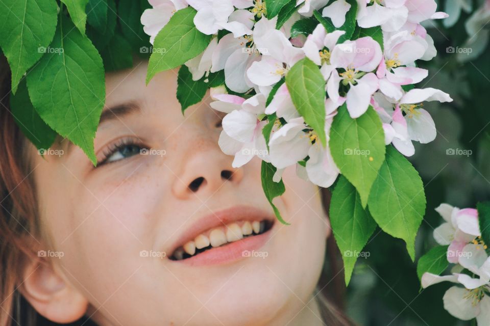 Girl smiling and looking at apple blossom