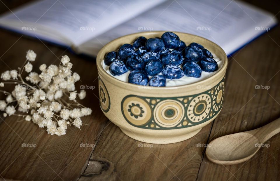 Yoghurt & blueberries in a retro bowl with wooden spoon.