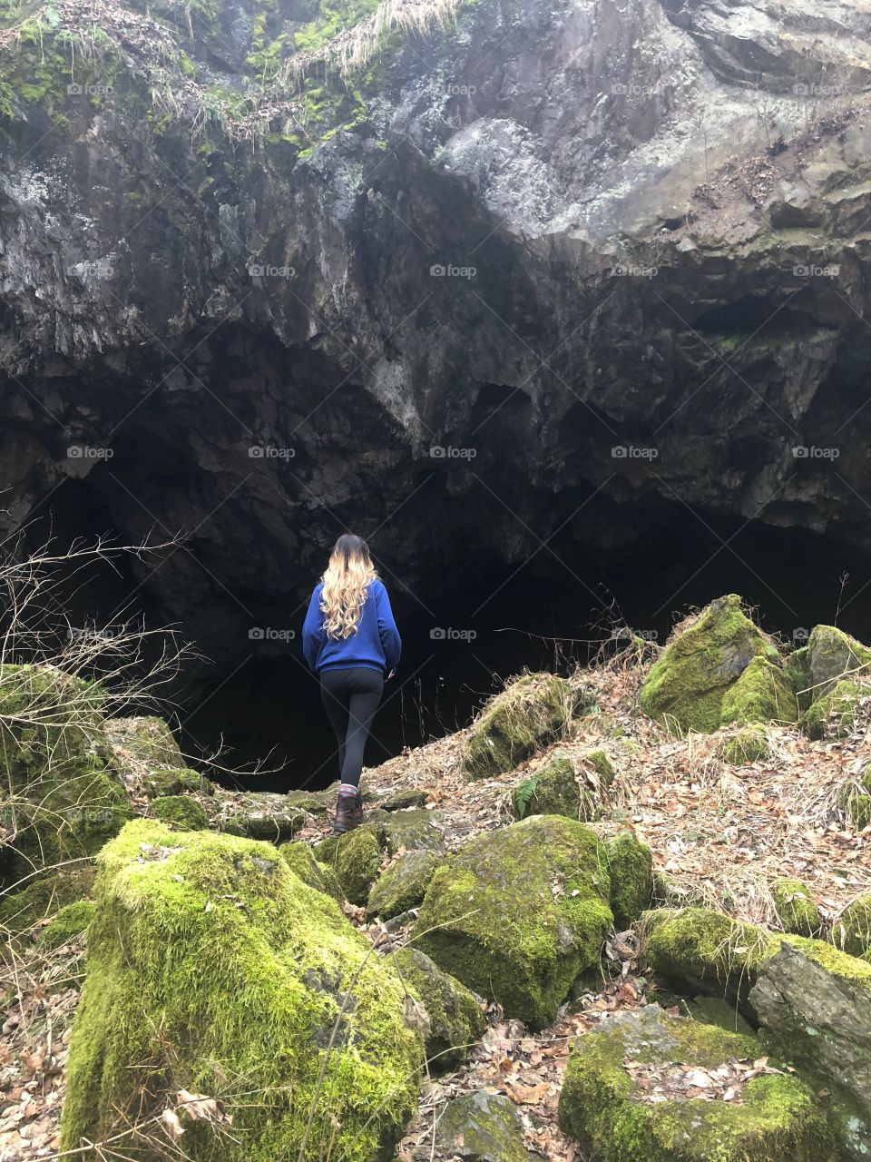 Woman walking into cave