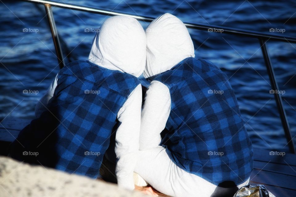 identical twins sitting on edge of boat