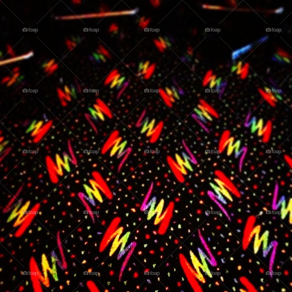 Gay rainbows zigzag across the floor at the gay bar.