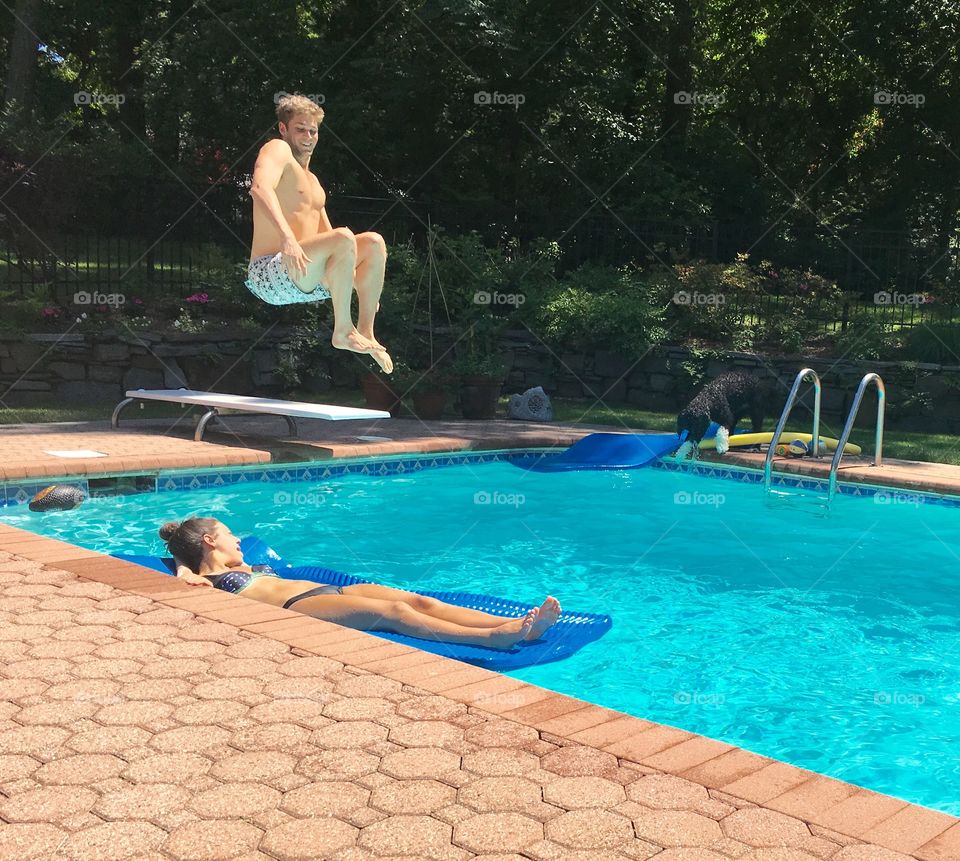 Young jumping into swimming pool