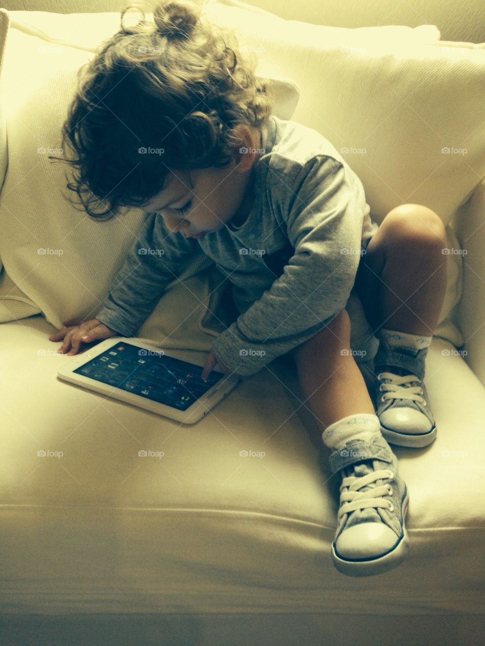 Chlopiec siedzi na sofie i ogłada bajki