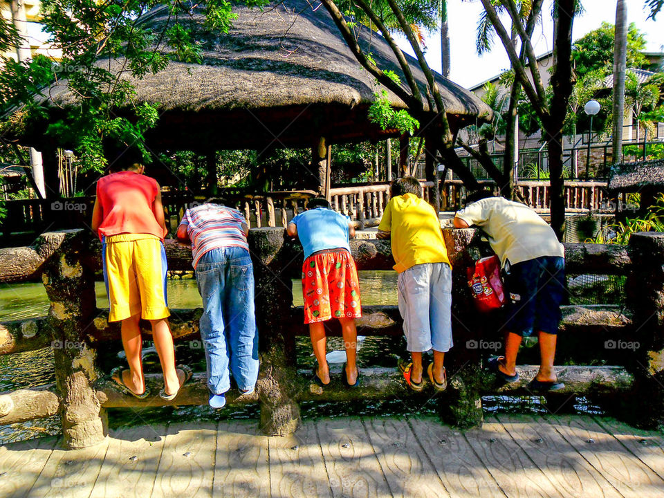 asian boys watching over a bridge