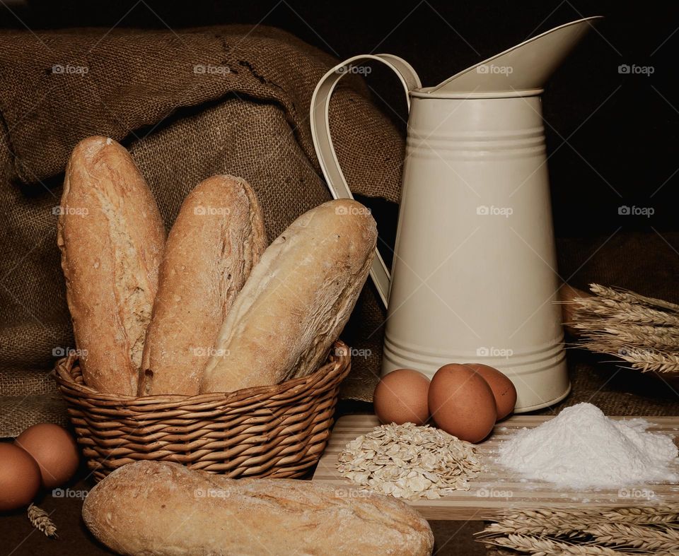 Warm toned farmhouse kitchen display with milk, eggs, bread, flour and oats
