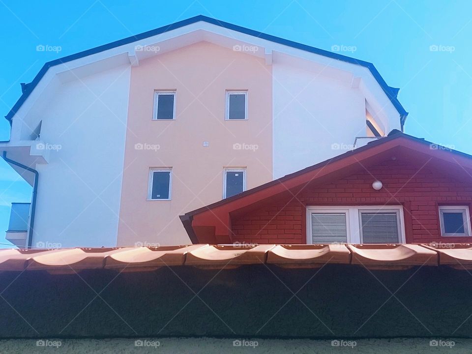 Red house and white pink building behind.  Representation of geometric shapes: circle,  triangle,  rectangle,  hexagon, or heptagon