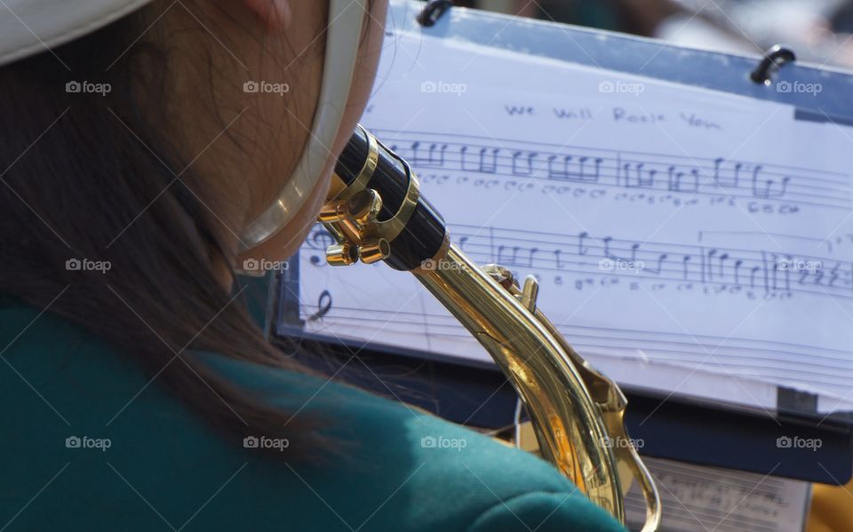 A back view  of a teenager girl performing in a marching band at St Patrick's Day Paradev in Park Slope, Brooklyn, NYC