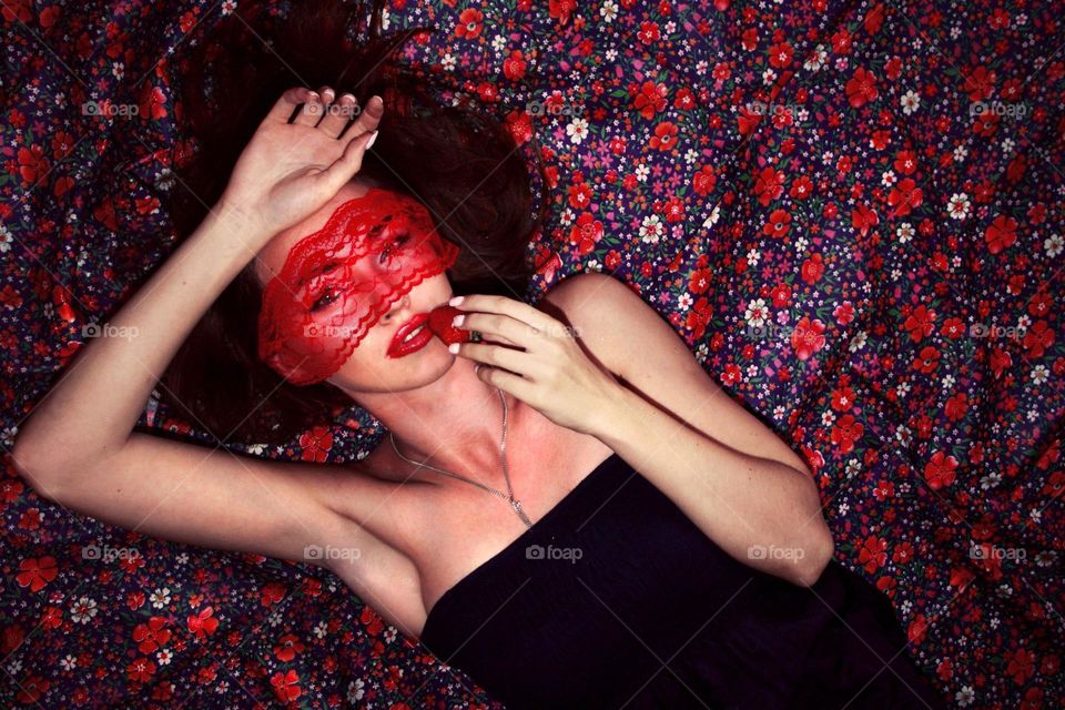 High angle view of woman lying with strawberry