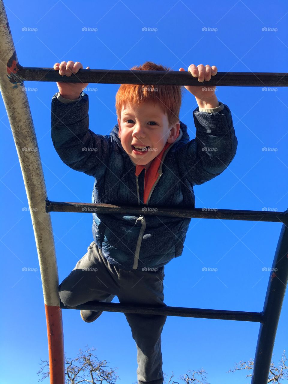 Toddler having fun on the monkey bars. 