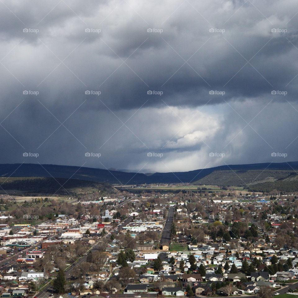 View from the Ochoco State Scenic Viewpoint of the town of Prineville, home of a growing technology sector, in Central Oregon with an intense sky from a rainstorm passing through. 