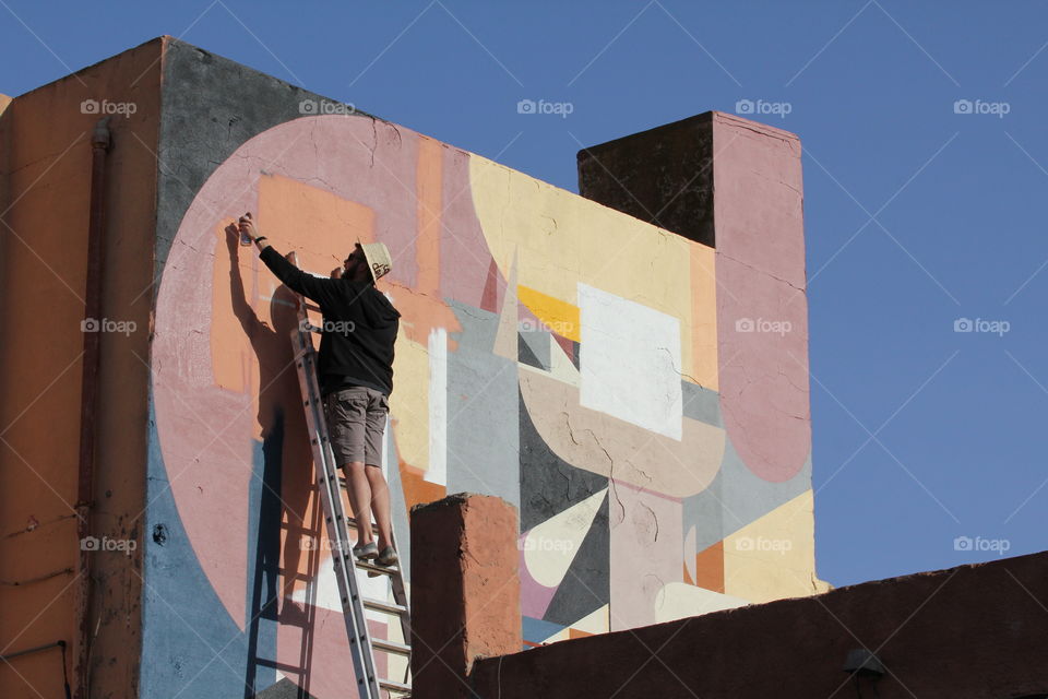 Man painting colorful wall art in Marrakech 