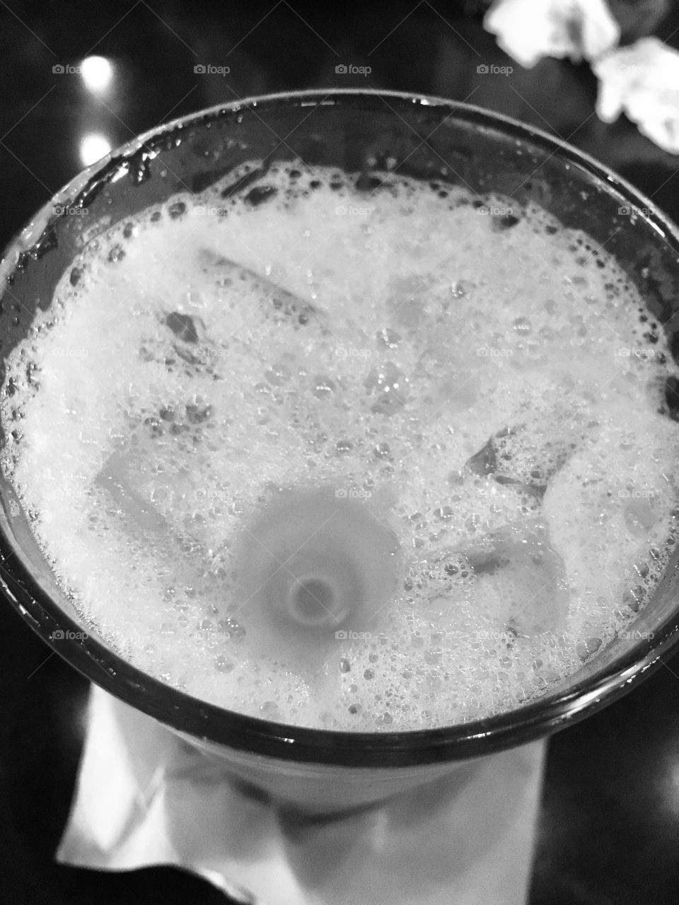 White bubbly drink with a straw and ice