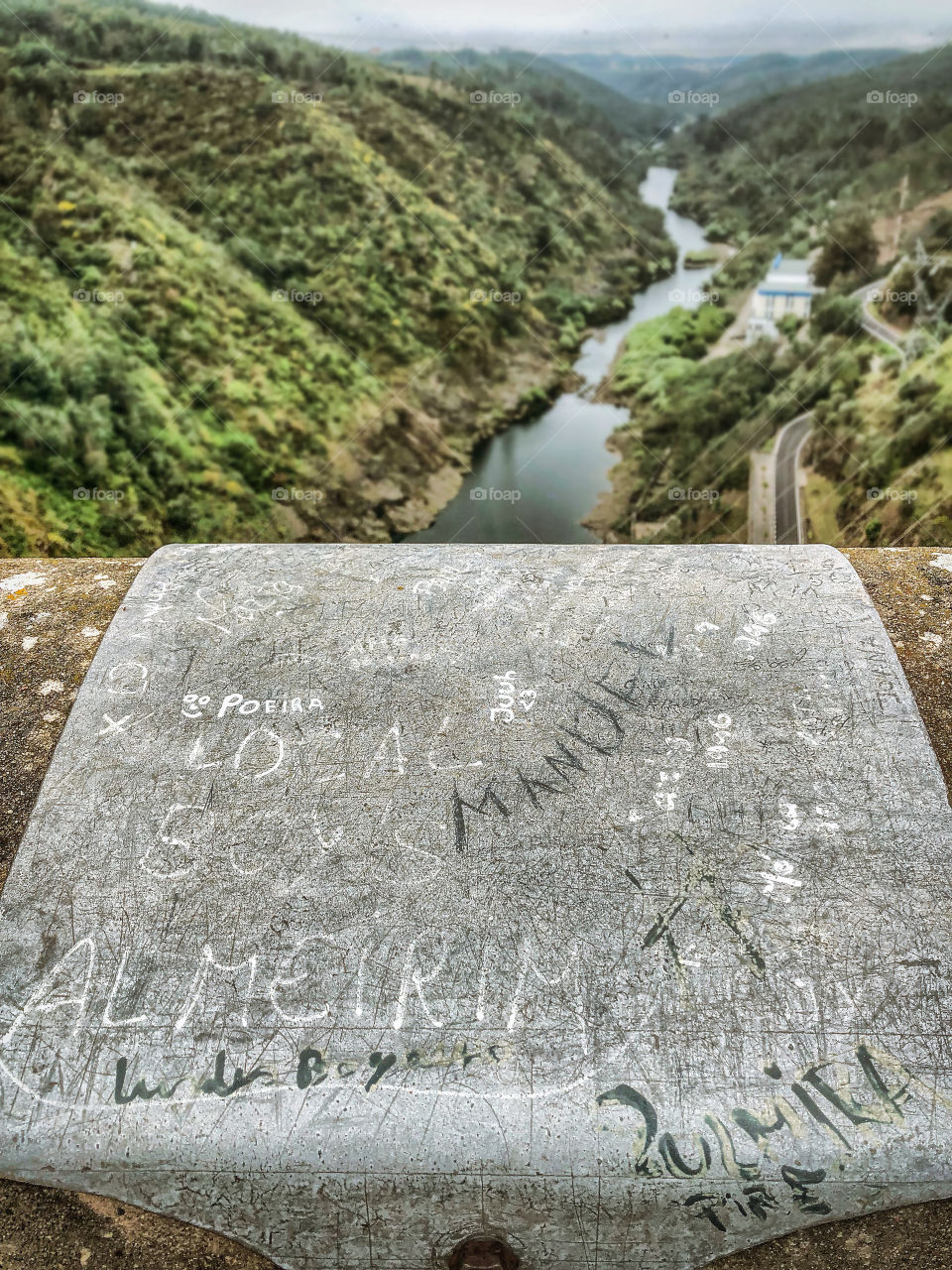 Graffiti in the concrete above Castelo Do Bode dam, the river stretches out into the distance