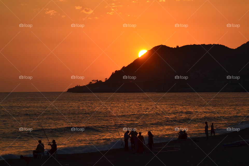 sunset in Alanya over fishermen on the beach.