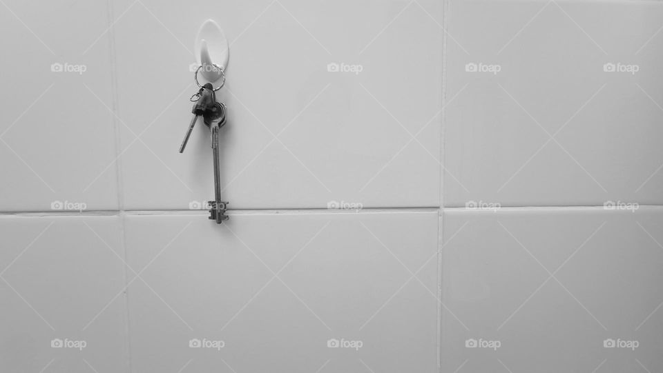 the key hangs on the wall, the key is on the hook, black and white photo, minimalism,