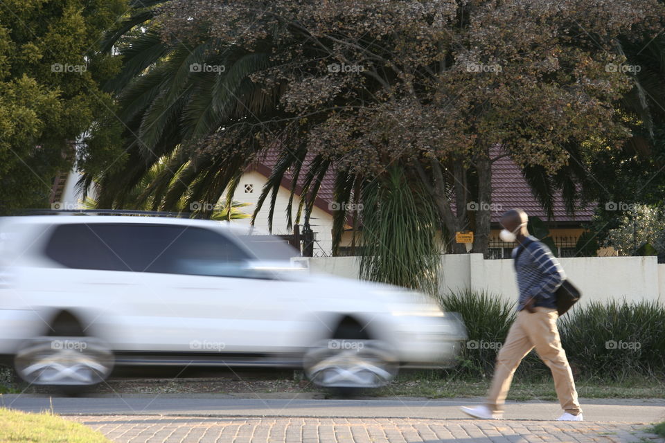 Moving car and pedestrian frozen in time. 