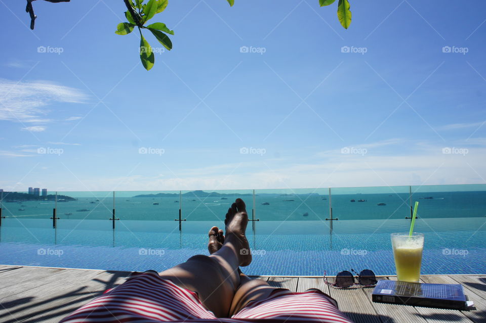relax swimming pool with book and cocktail island view