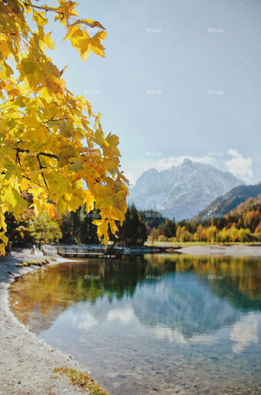 Autumn background of the Alps mountains landscape against blue lake Jasna in Slovenia.