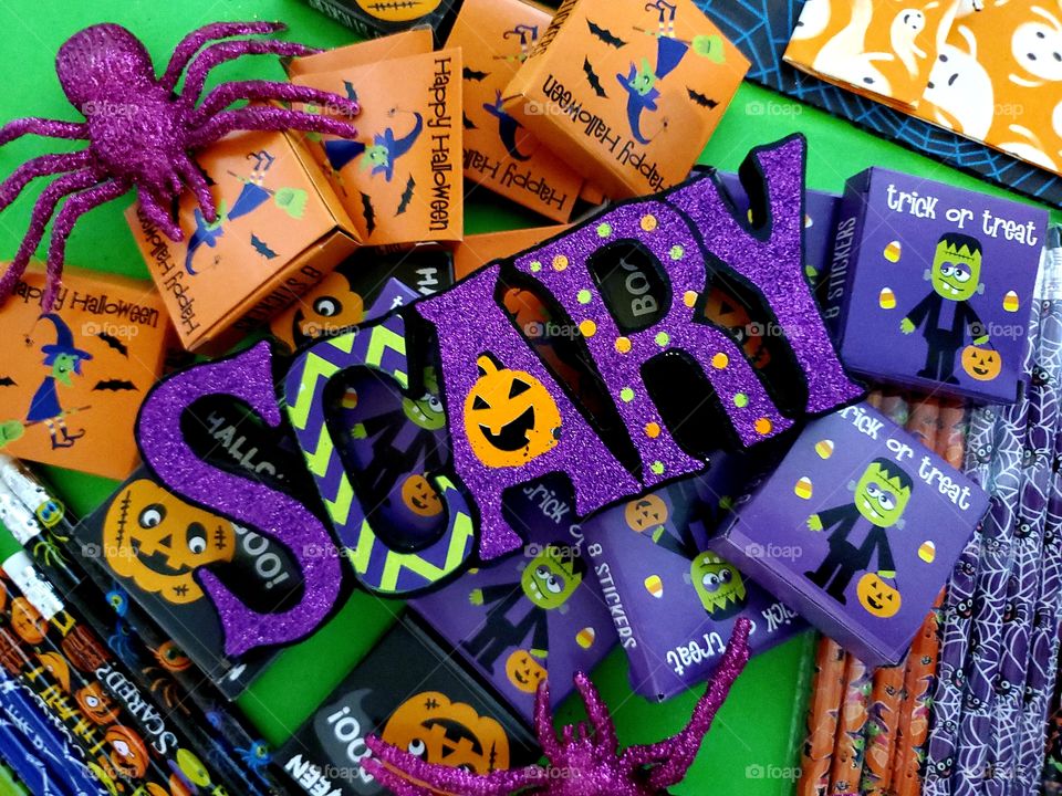 Halloween flat lay with the word scary and kids treats  with a bright green background