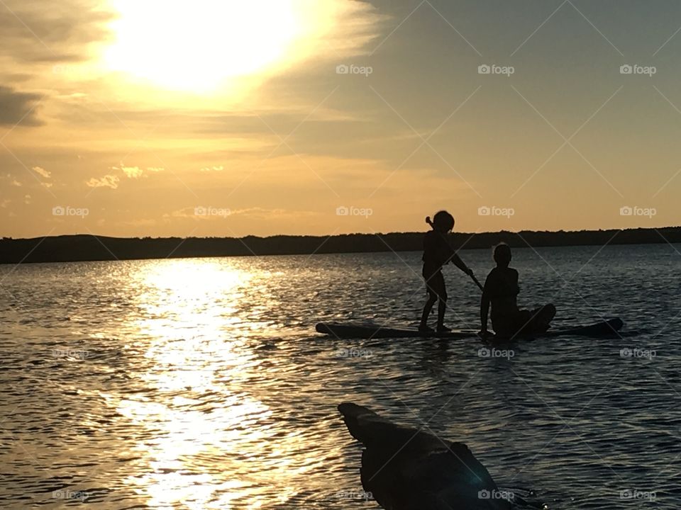 A mother and her daughter paddle by as the sun sets behind them. Great day on the water
