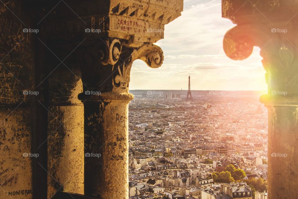 The sun setting over the streets of Paris, featuring the Eiffel Tower, as seen from the Sacre Ceour cathedral.