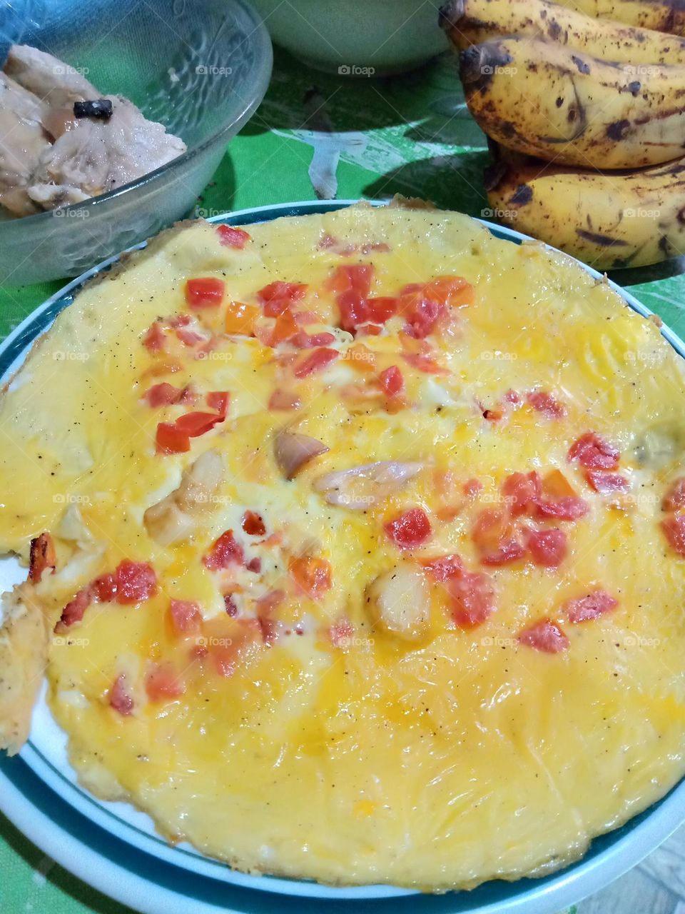 for breakfast,,  fried egg with  red tomatoes and powdered black pepper, together with bananas