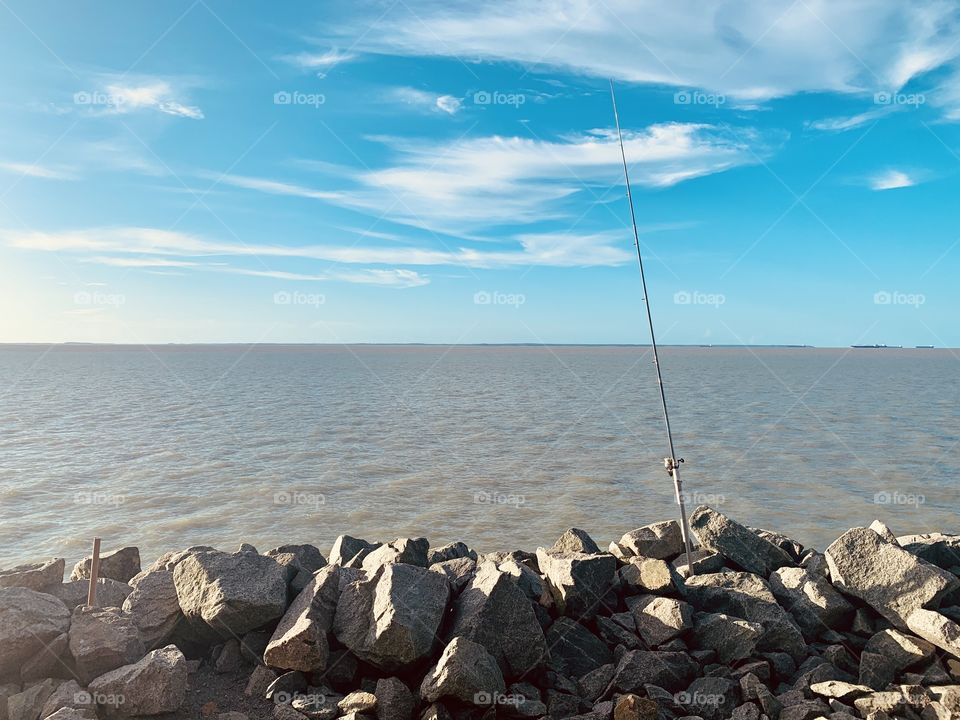 Sky, sea, rocks and fishing rod in São Luís Maranhão Brazil 