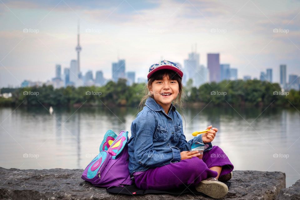 Cute little girl is having a snack outdoors