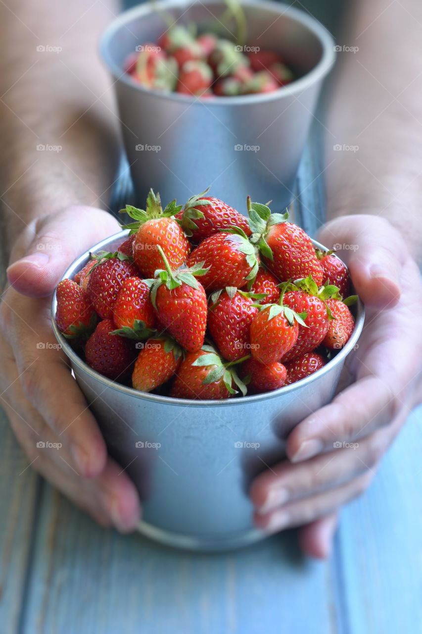 Person holding fresh strawberries 