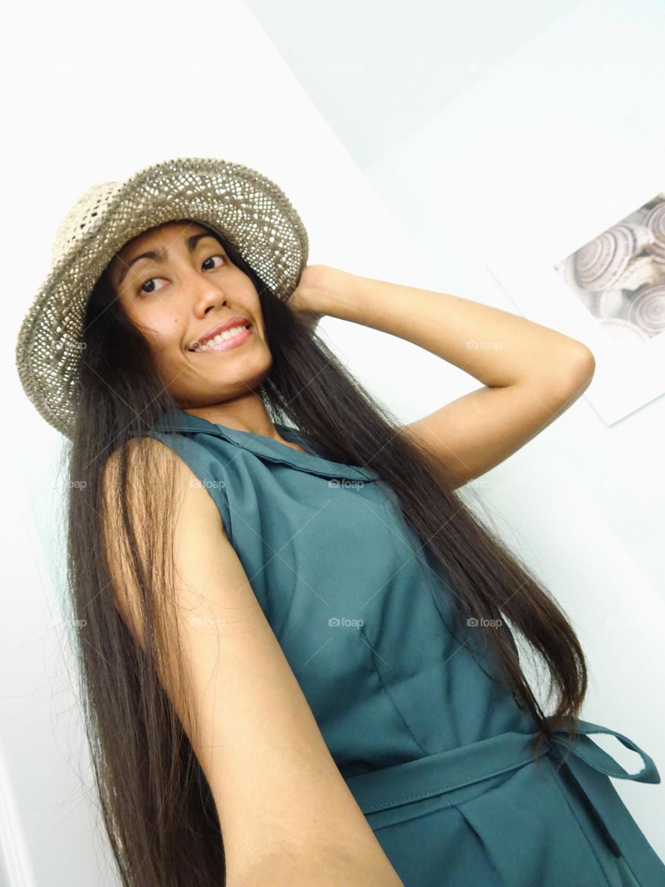 A woman with long hair wearing a hat and green clothes 