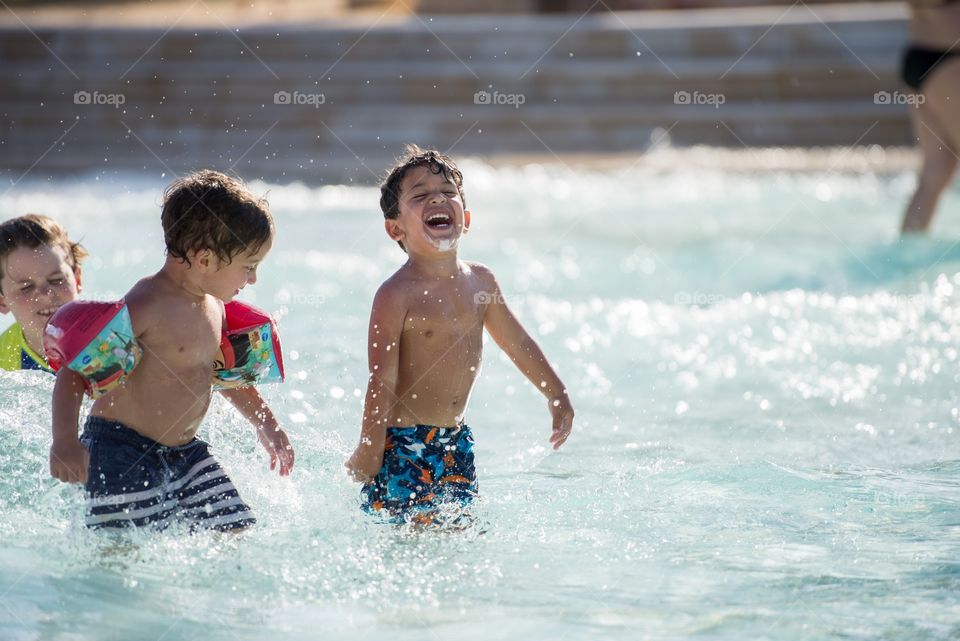 boy playing in the swimming pool happily