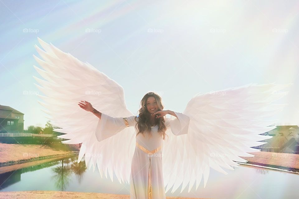 Model dressed as an Angel with a pond and the sun in the background!