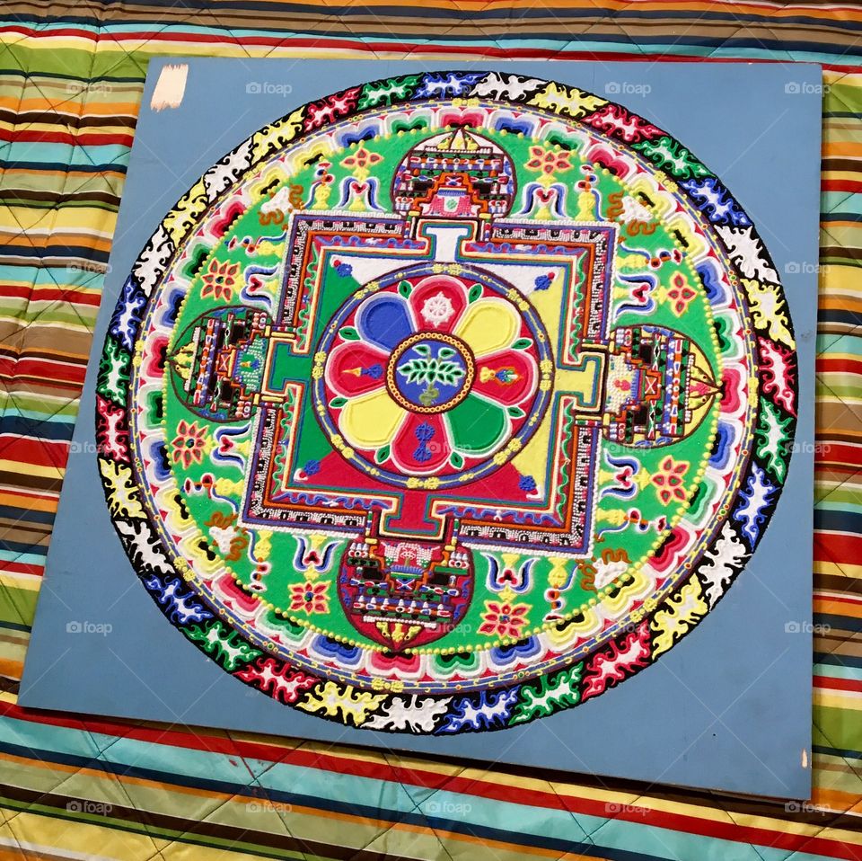 A colorful, intricate sand mandala, rife with symbolic meaning
