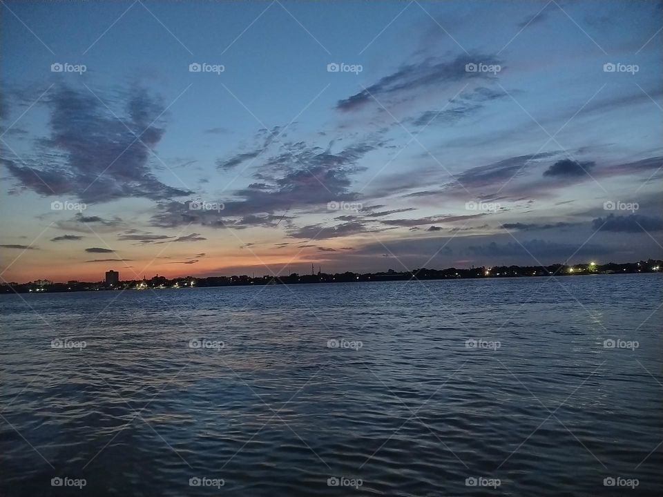 The Sun sets beyond the horizon of The Ganges