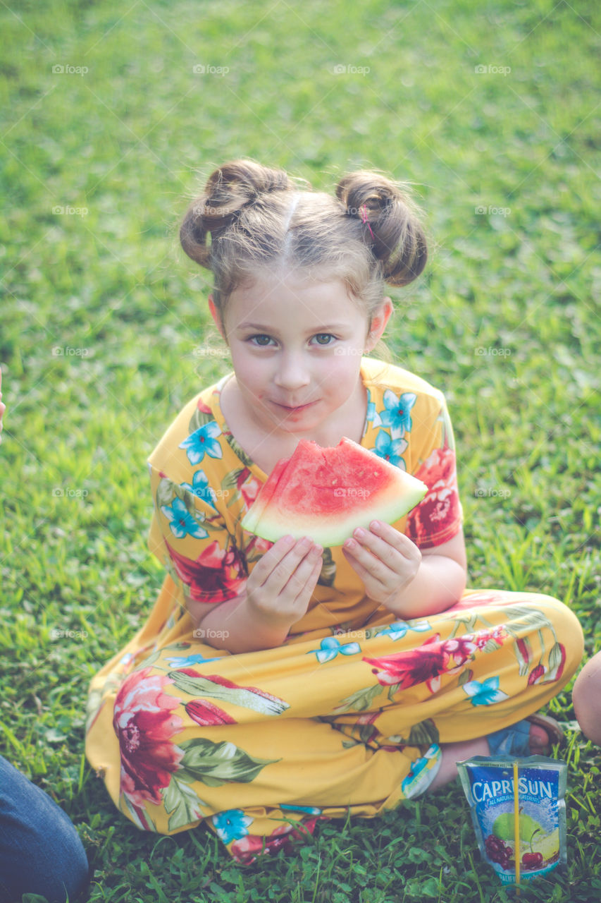 Young Girl Eating Watermelon with Capri Sun 