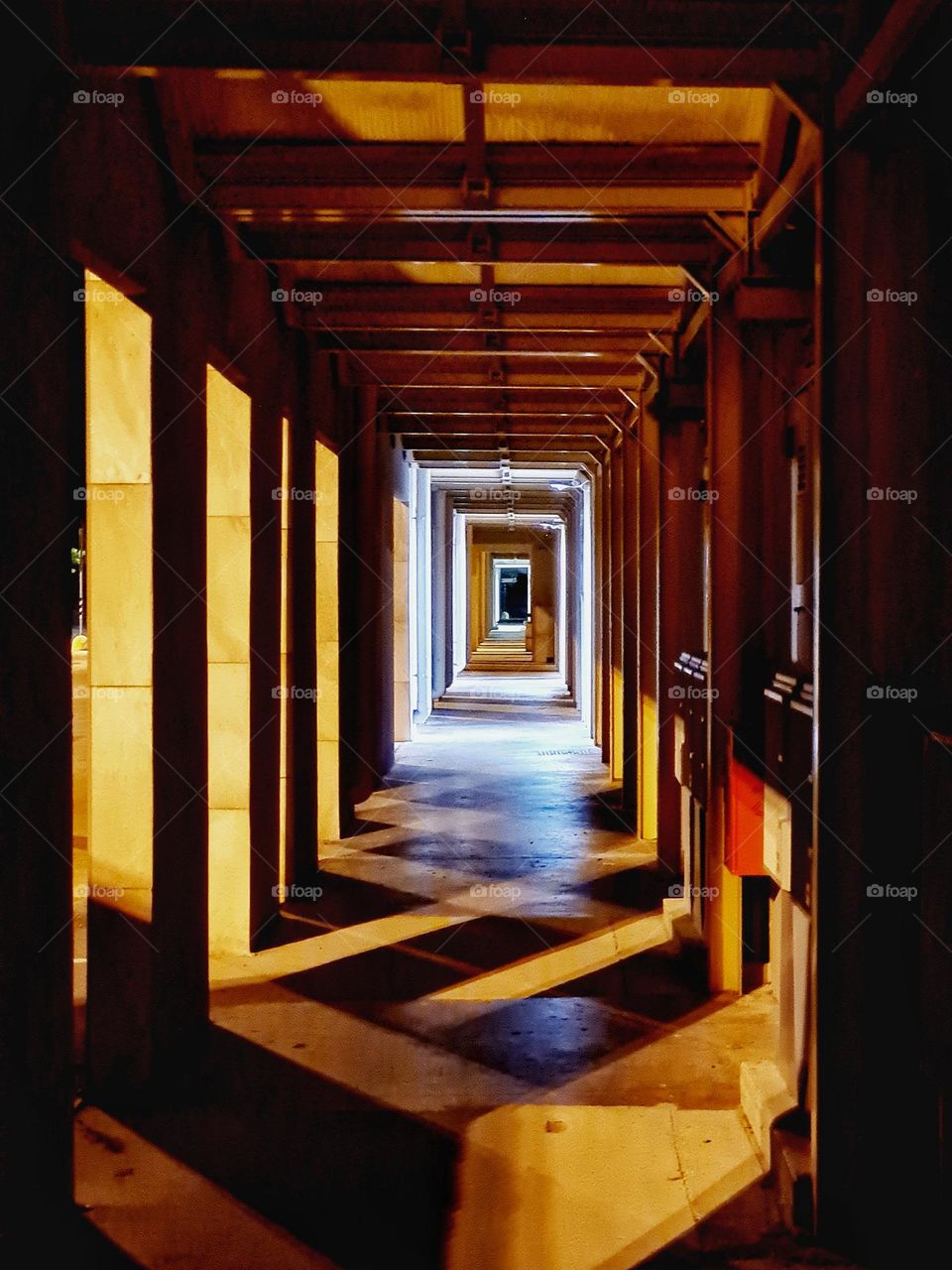 colonnade photographed at night between lights and shadows