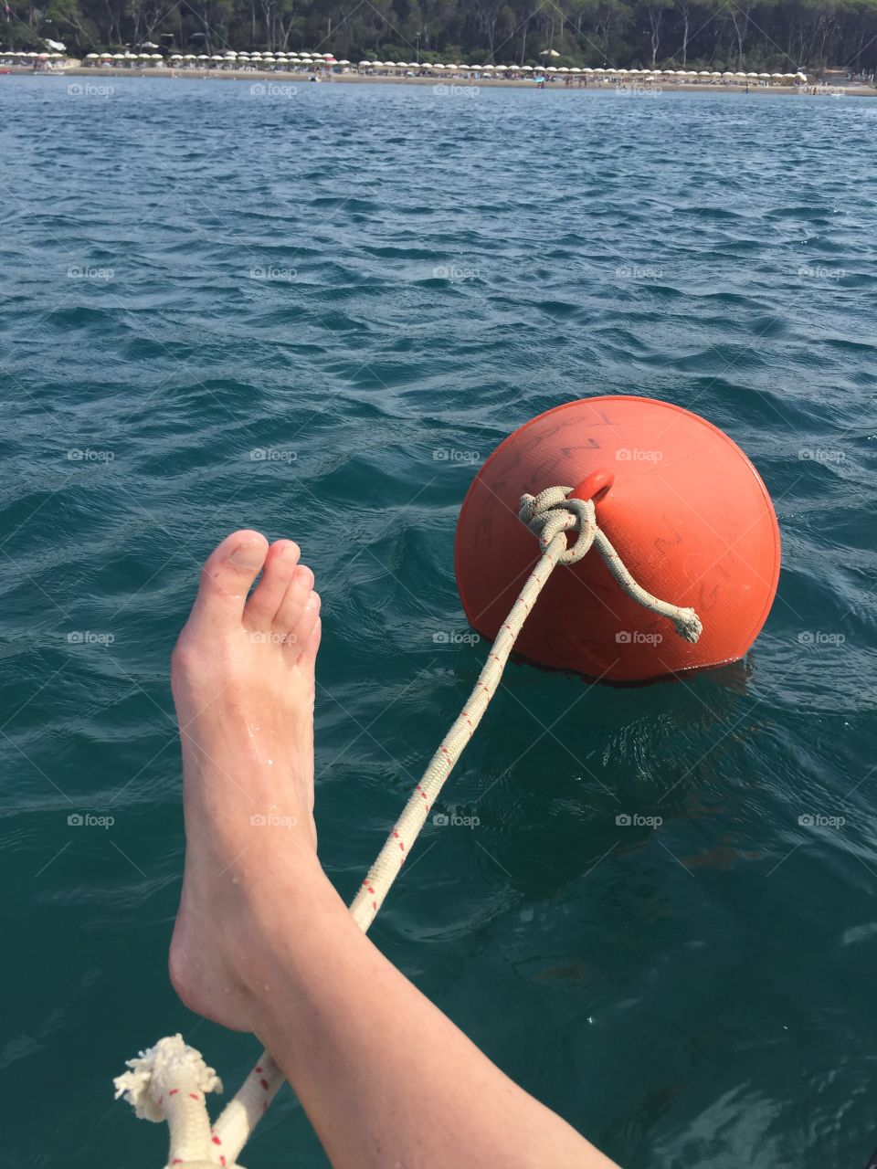 A foot and a red floating buoy on the sea 