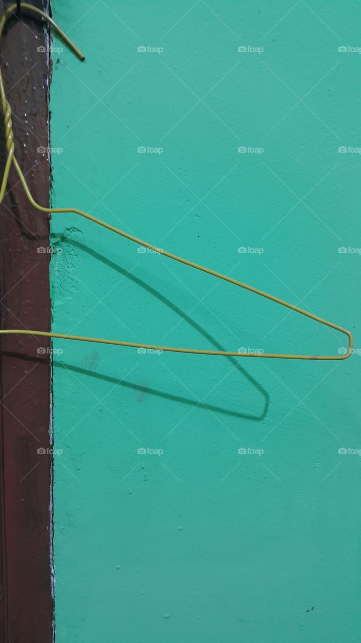 thin hanger: shadow on the green wall