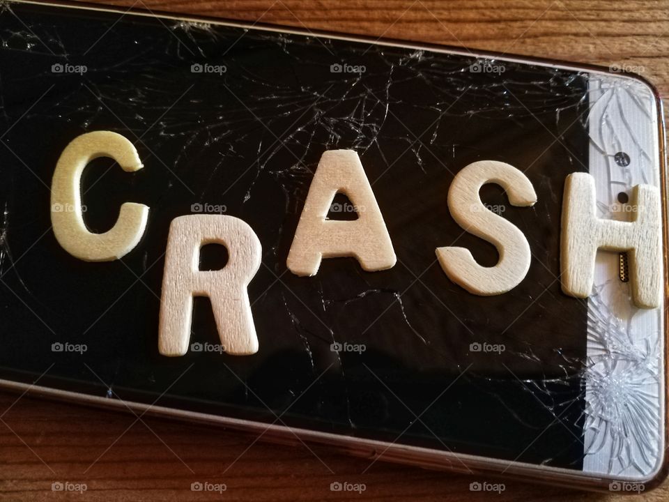 Cellphone with broken and written glass: "crash"