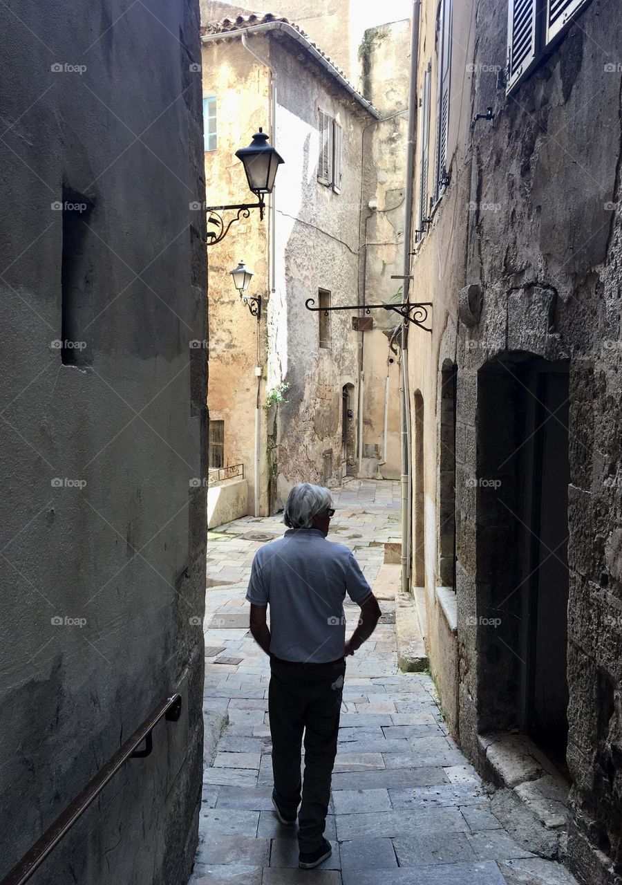 Nice man walking in narrow street of Provence village