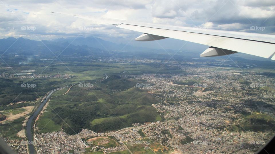 view from the airplane: green mountains vs crowded urbanization - Rio de Janeiro Brazil