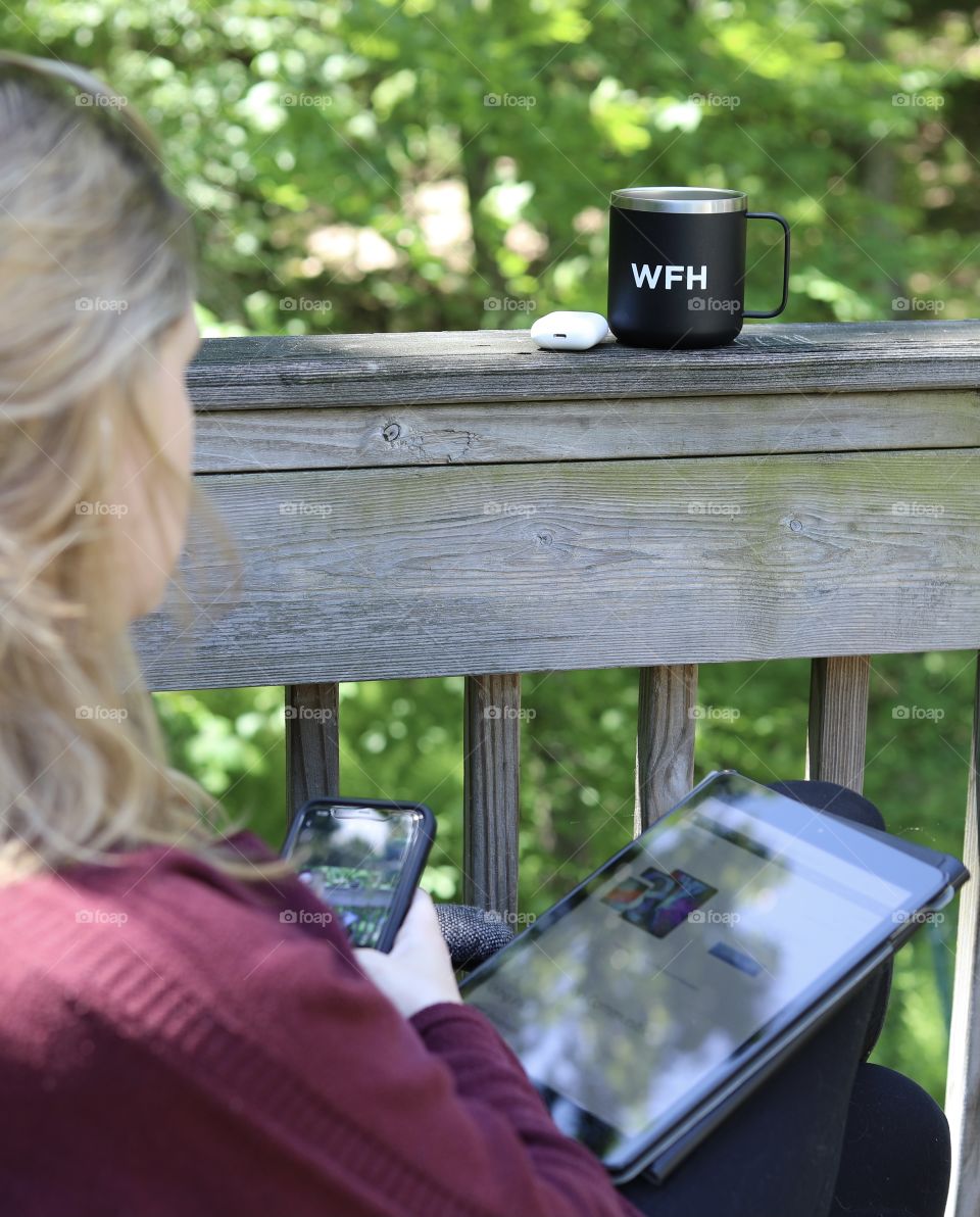 Woman using iPhone 11 Pro Max Wifi Connect to capture pictures while using a Gen 7 iPad and Gen 2 Airpods with a “Work From Home” Coffee Cup