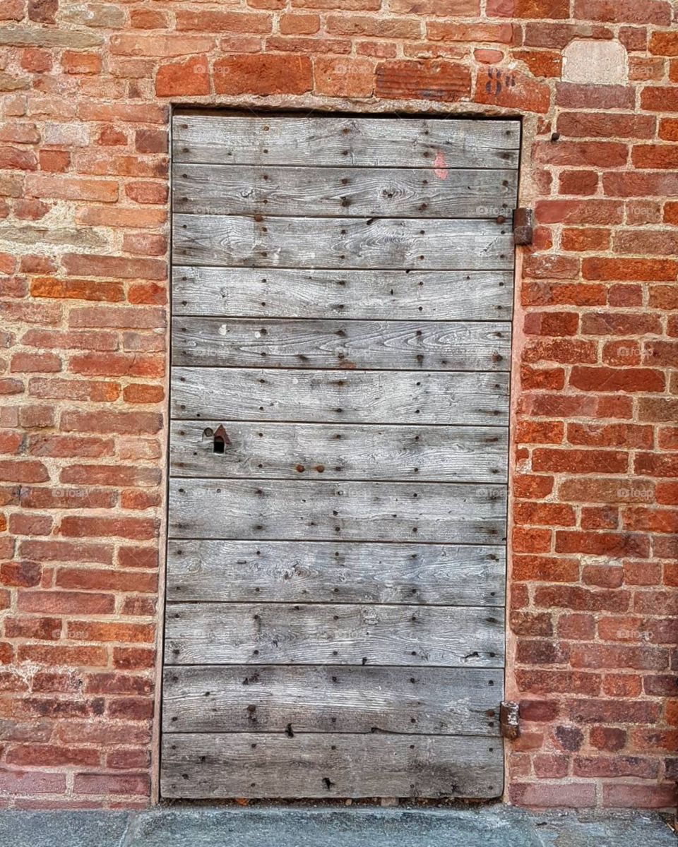 Ancient wood door in a brick wall