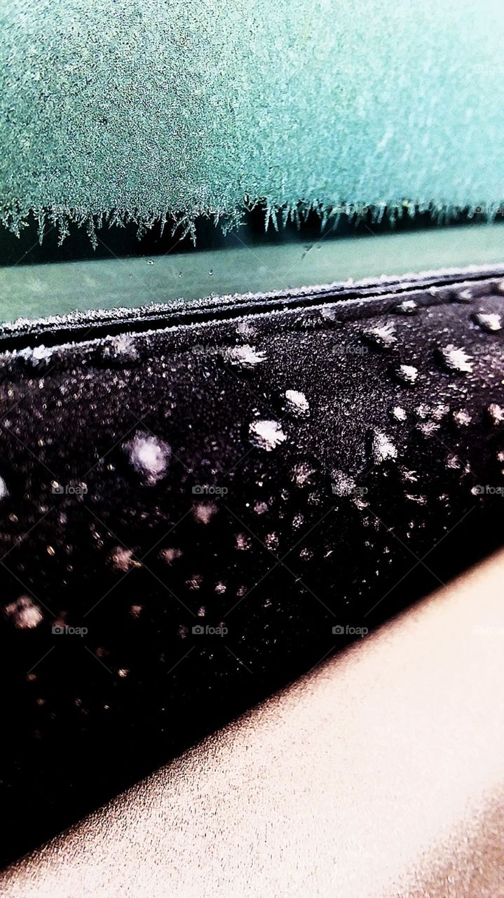 Tiny bits of beautiful ice crystals that formed on the side of a car in the freezing weather