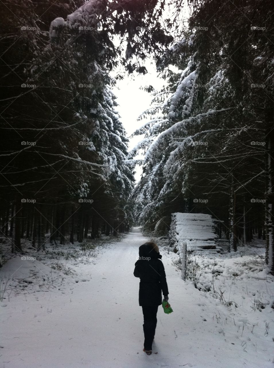 Rear view of a woman standing on snowy street
