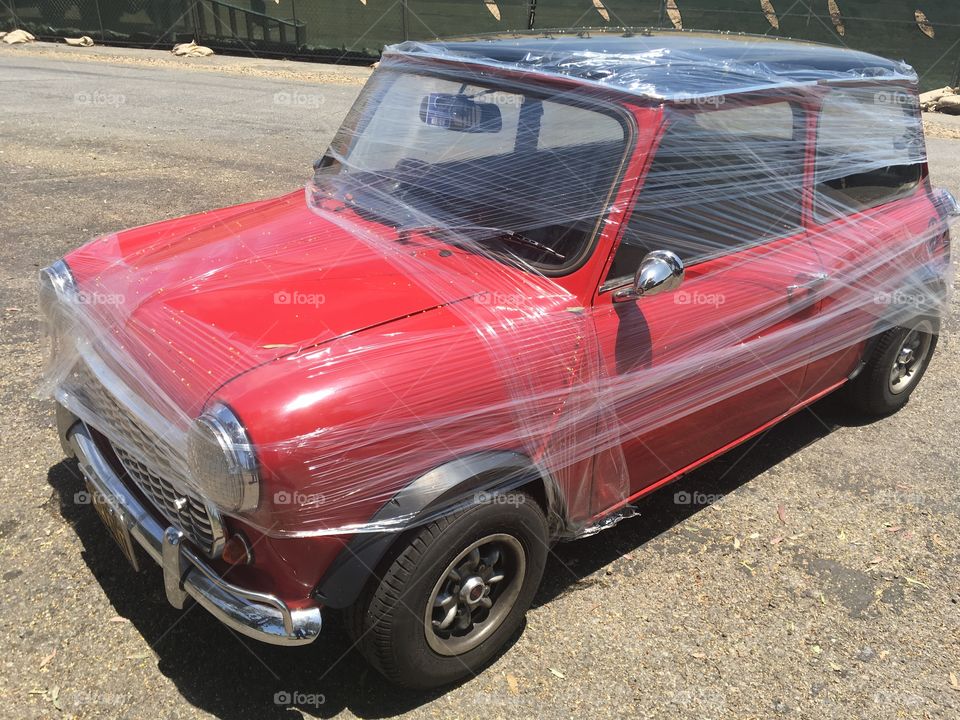 Mini European car is wrapped in plastic wrap. Prank that makes it look like the car is getting ready to be shipped 